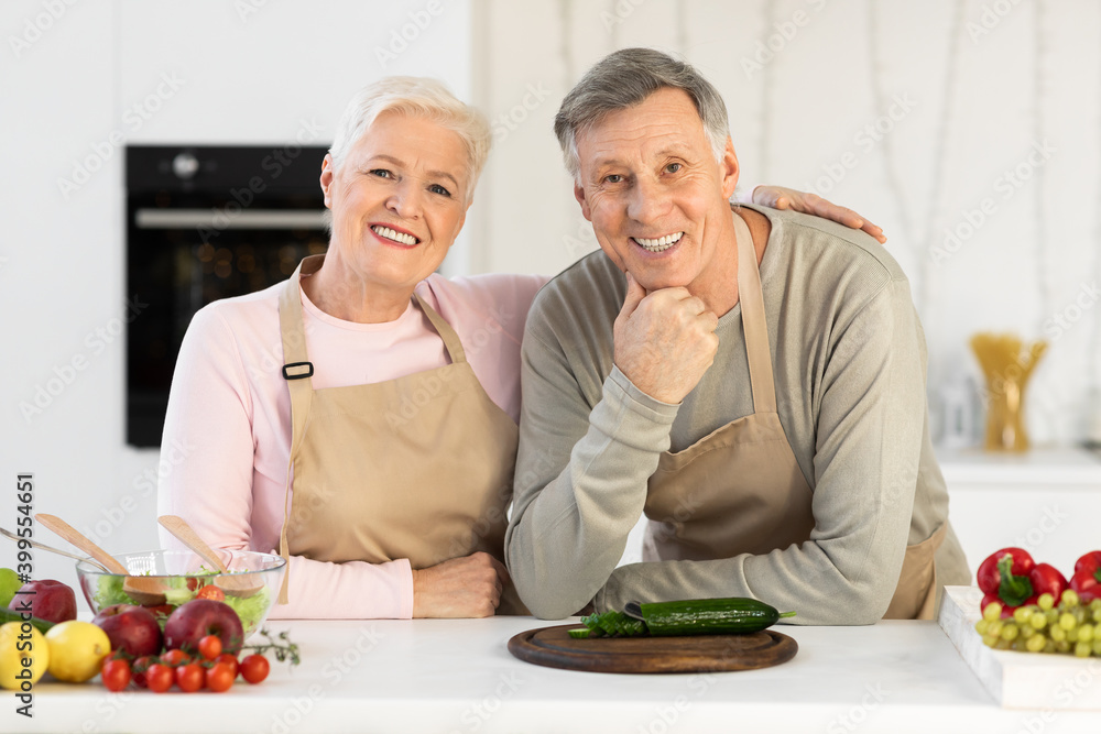 Happy Senior Couple Posing In Kitchen, Hugging Cooking Dinner Together Happy Senior Couple Posing In Kitchen, Hugging Cooking Dinner Together