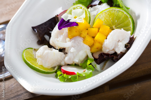 Refreshing merluccius ceviche with lime and ripe mango