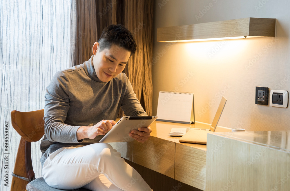 Asian business men work on their laptops, watch their diagrams, save time, plan their work at home.Work for Home concept. Asian business men work on their laptops, watch their diagrams, save time, plan their work at home.Work for Home concept.