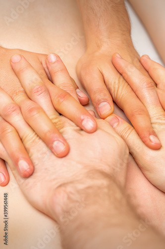 4 hands massage the patient back. Two masseurs doing massage. Closeup © okskukuruza