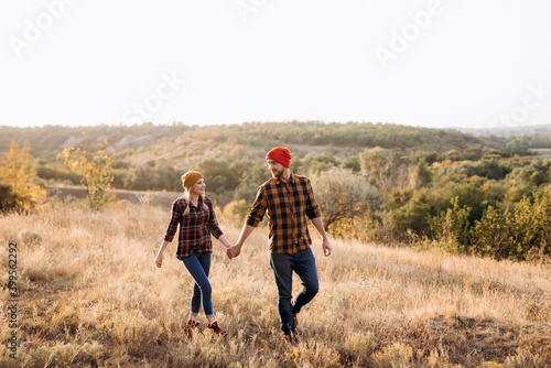 Cheerful guy and girl on a walk in bright knitted hats