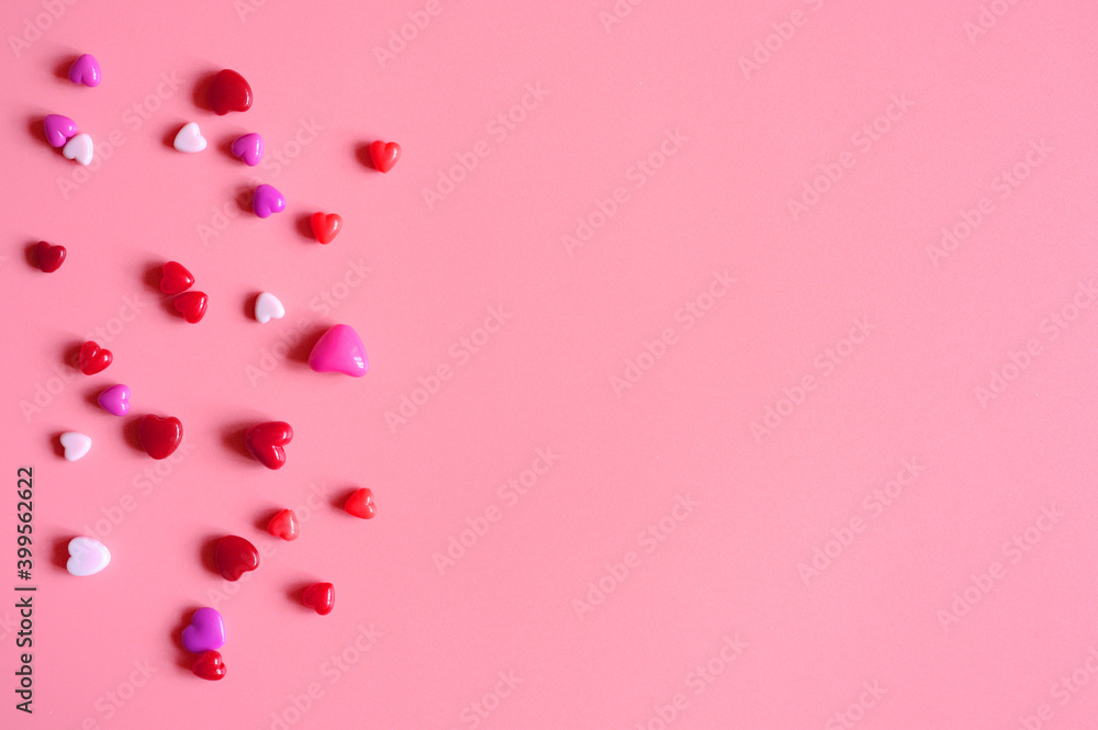 a heap of heart shaped glossy beads in different pink shades on a pink background. space for text a heap of heart shaped glossy beads in different pink shades on a pink background. space for text