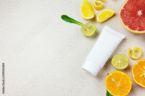 
white cosmetic tube with citrus slices. cosmetic concept with fruit acids and vitamin c. Copy space
