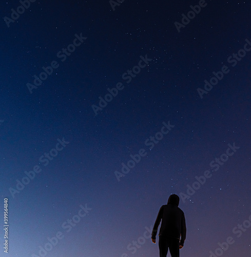 Silhouette of a person looking at the sky full of stars