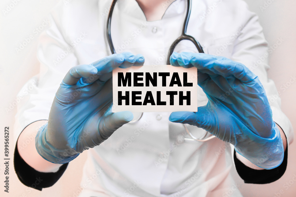The doctor's blue - gloved hands show the word MENTAL HEALTH - . a gloved hand on a white background. Medical concept. the medicine The doctor's blue - gloved hands show the word MENTAL HEALTH - . a gloved hand on a white background. Medical concept. the medicine