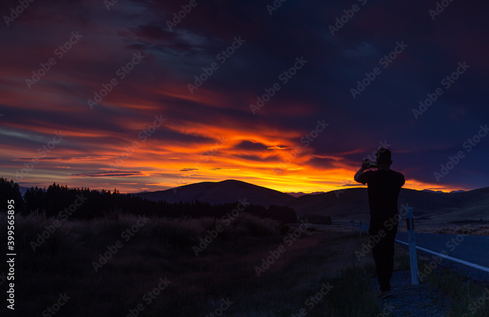 Humbling view of a red as fire sunset in New Zealand Burkes Pass from the highway side