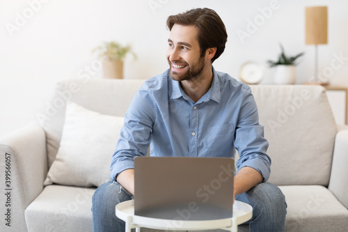 Cheerful Businessman Works On Laptop Online Sitting At Home © Prostock-studio