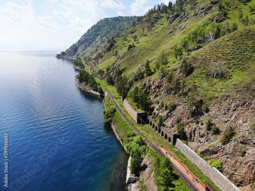 Old stone arch tunnel in mountain the rock on the Circum-Baikal railway in summer. Baikal lake from the air