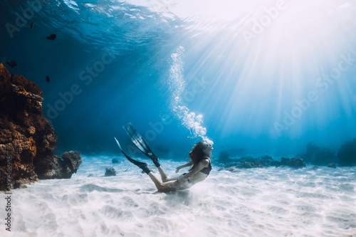 Young woman freediver make bubbles in deep sea. Freediving in ocean