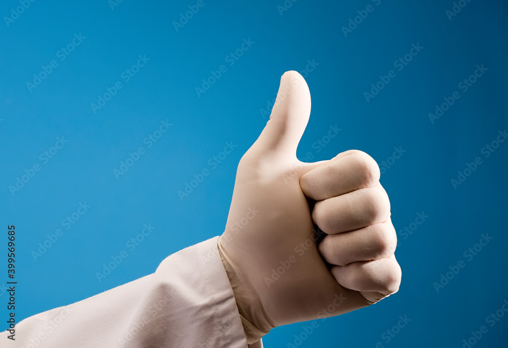 hand of doctor doing ok symbol, with surgical glove and blue background hand of doctor doing ok symbol, with surgical glove and blue background