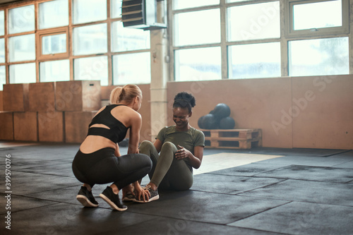 Young woman doing sit-ups in a gym with a partner