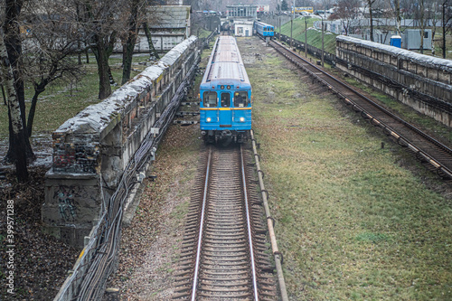 Blue subway train Ezh runs along the railway in cloudy day. Yezh-3 train - Kyiv, Ukraine