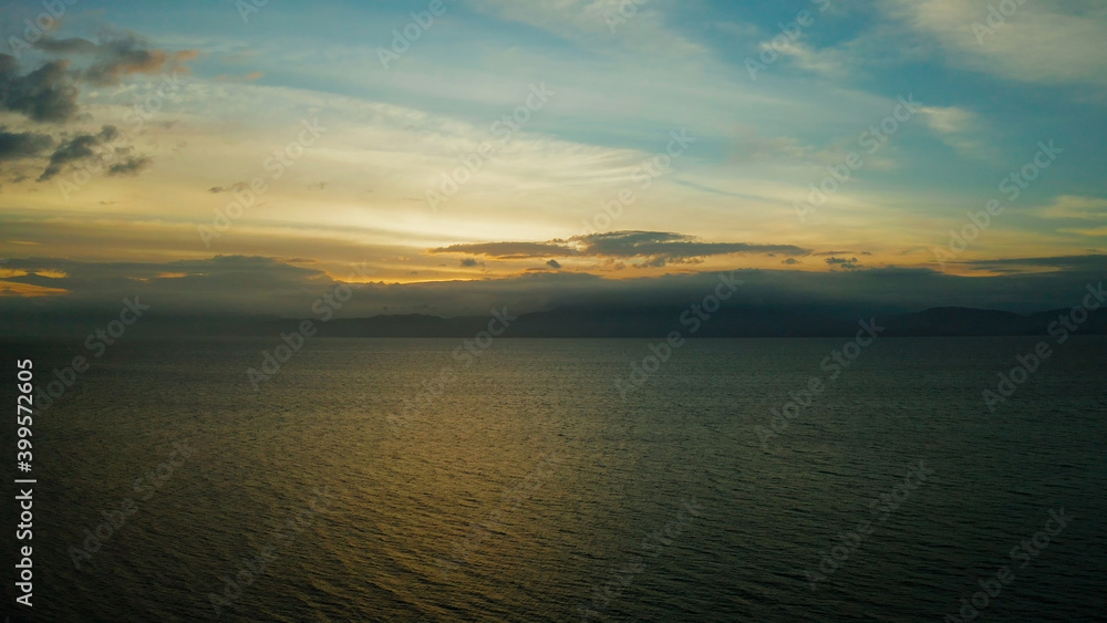 Colorful bright clouds during sunset over the sea, aerial view. Sunset over ocean. Seascape, Summer and travel vacation concept, Moalboal, Philippines.