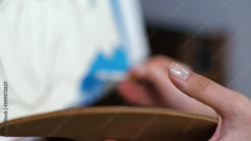Young blond woman artist paints a picture in blue colors. Macro Palette Young blond woman artist paints a picture in blue colors. Macro Palette