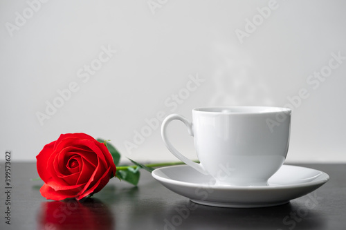 Red rose and coffee cup on the wood table