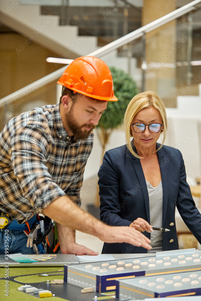 mature designer woman discuss plan strategy of building with engineer, blonde pleasant female give directions, share opinion with architect engineer mature designer woman discuss plan strategy of building with engineer, blonde pleasant female give directions, share opinion with architect engineer