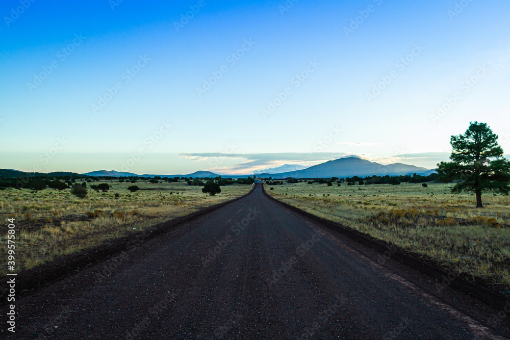 Beautiful road to the horizon in the middle of nowhere during sunrise.