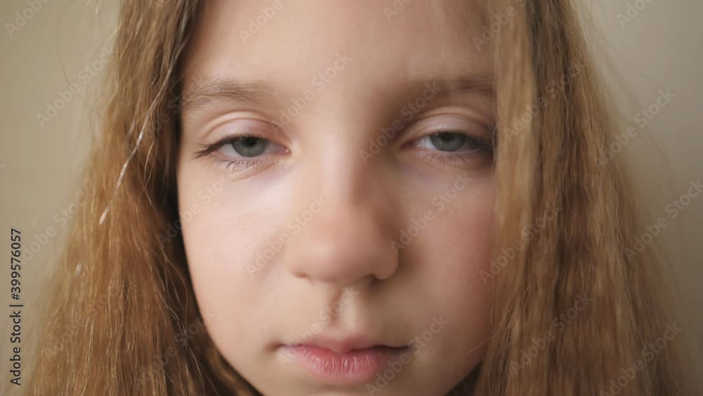 Close up female face of desperate child looking into camera indoor. Disappointed gaze of small upset kid. Portrait of little blonde girl with sorrowful expression inside Close up female face of desperate child looking into camera indoor. Disappointed gaze of small upset kid. Portrait of little blonde girl with sorrowful expression inside