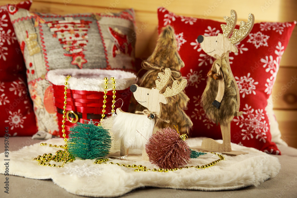 New year atmosphere at home. Red and white colours. December day. Deer, Christmas tree, beads. 
Christmas decorations for home