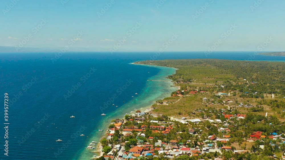 Shore with hotels near coral reef and diving boats, Moalboal, Philippines. Aerial view, Summer and travel vacation concept.