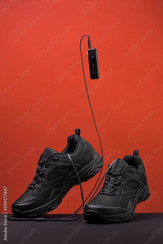 a pair of black sneakers on a colored background with music