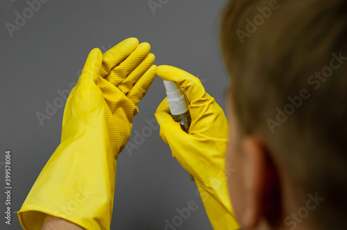Yellow gloves with antiseptic on a yellow background.