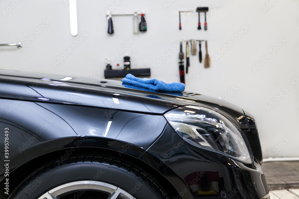 A set of black and red brushes hanging on a shelf on a white wall, a set of tools for working in a car workshop for detailing, painting, polishing and dry cleaning.