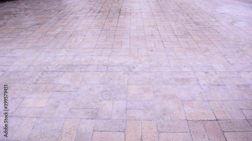 Pedestrian's feet carefully slide along the sidewalk covered with slippery ice. Winter weather is surprising. The sharp drop in temperature froze the raindrops, covering everything with slippery ice.
