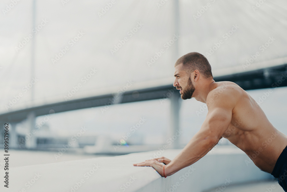 Motivated male sportsman does push up exercise poses outdoor at bridge  concentrated into distance has morning workout naked muscular torso warms up  before jogging. Healthy lifestyle concept. Stock Photo | Adobe Stock