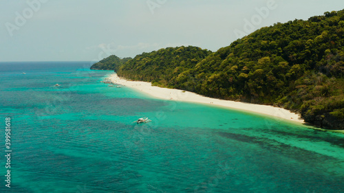Tropical beach with palm trees and turquoise waters of the coral reef, top view, Puka shell beach. Boracay, Philippines. Seascape with beach on tropical island. Summer and travel vacation concept.