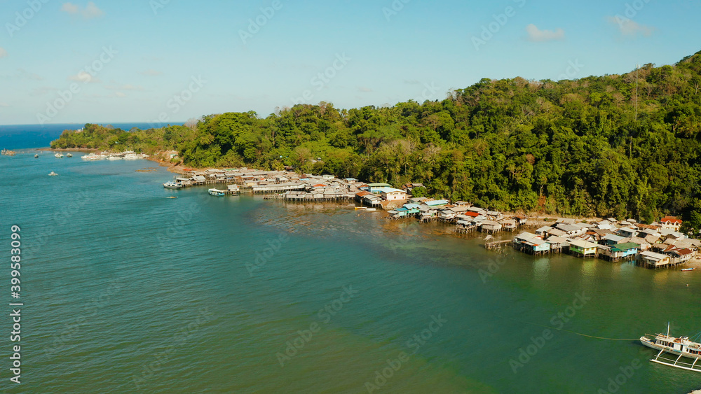 Houses community standing in water in fishing village. City port on Balabac island, Palawan, Philippines. Old wooden house standing on the sea in the fishing village