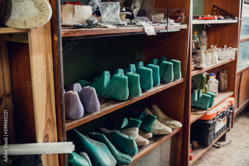 Colorful blanks for shoes are on the shelves in the cabinet in the shoe production studio.