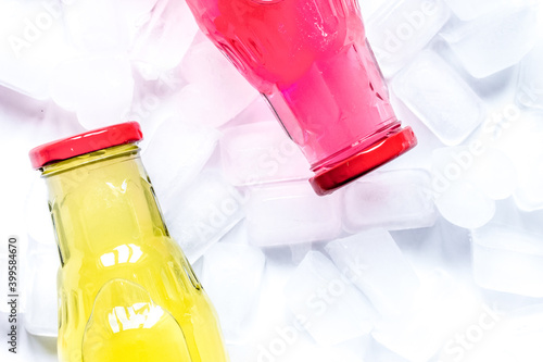 ice cubes and bright bottles on white background top view mock up