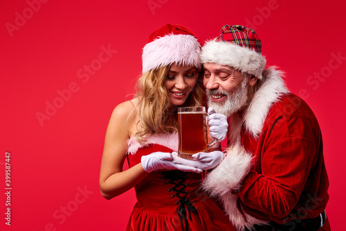 couple of snow maiden and santa going to drink beer, have party time, isolated on red background