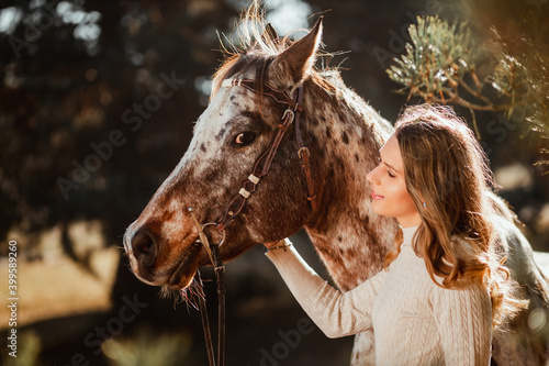 Beautiful young girl posing with her horse in the nature. Sunny autumn day. © mathefoto