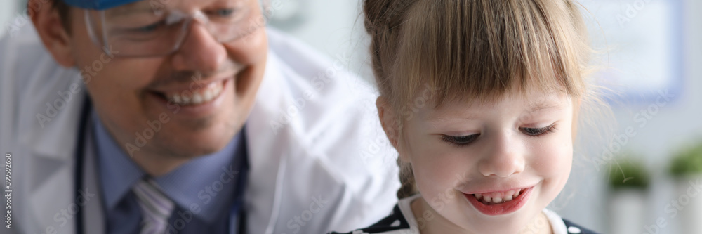 Portrait of little beautiful girl on consultation with pediatrician in clinic. Annual preventive examinations in children concept. Portrait of little beautiful girl on consultation with pediatrician in clinic. Annual preventive examinations in children concept.