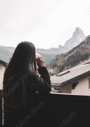 woman drinking coffee and looking at the mountain