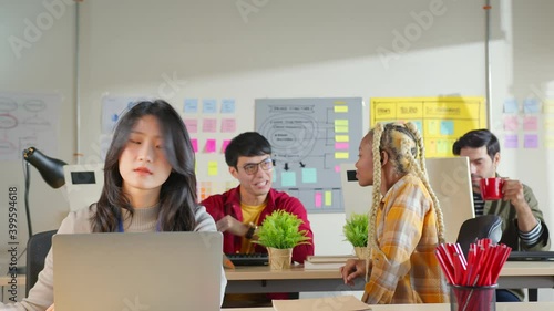 Creative young female and male ux ui designers working at modern office,two coworkers discussing fun project over a laptop, little team of business people smiling and workg together at creative agency photo