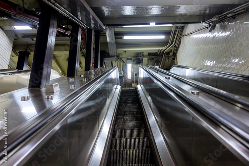 View from above of two-way escalators with staircase at subway