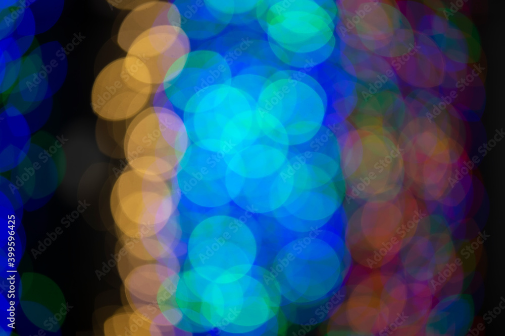Multi-colored large bokeh spots of blue, yellow and orange. Bokeh from a Christmas garland. Multi-colored large bokeh spots of blue, yellow and orange. Bokeh from a Christmas garland.
