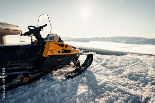 Snowmobile in the snow on the skiing hill of the ski area.ountain ski resort and winter calm mountain landscape. Winter ski resort - popular travel destination photo