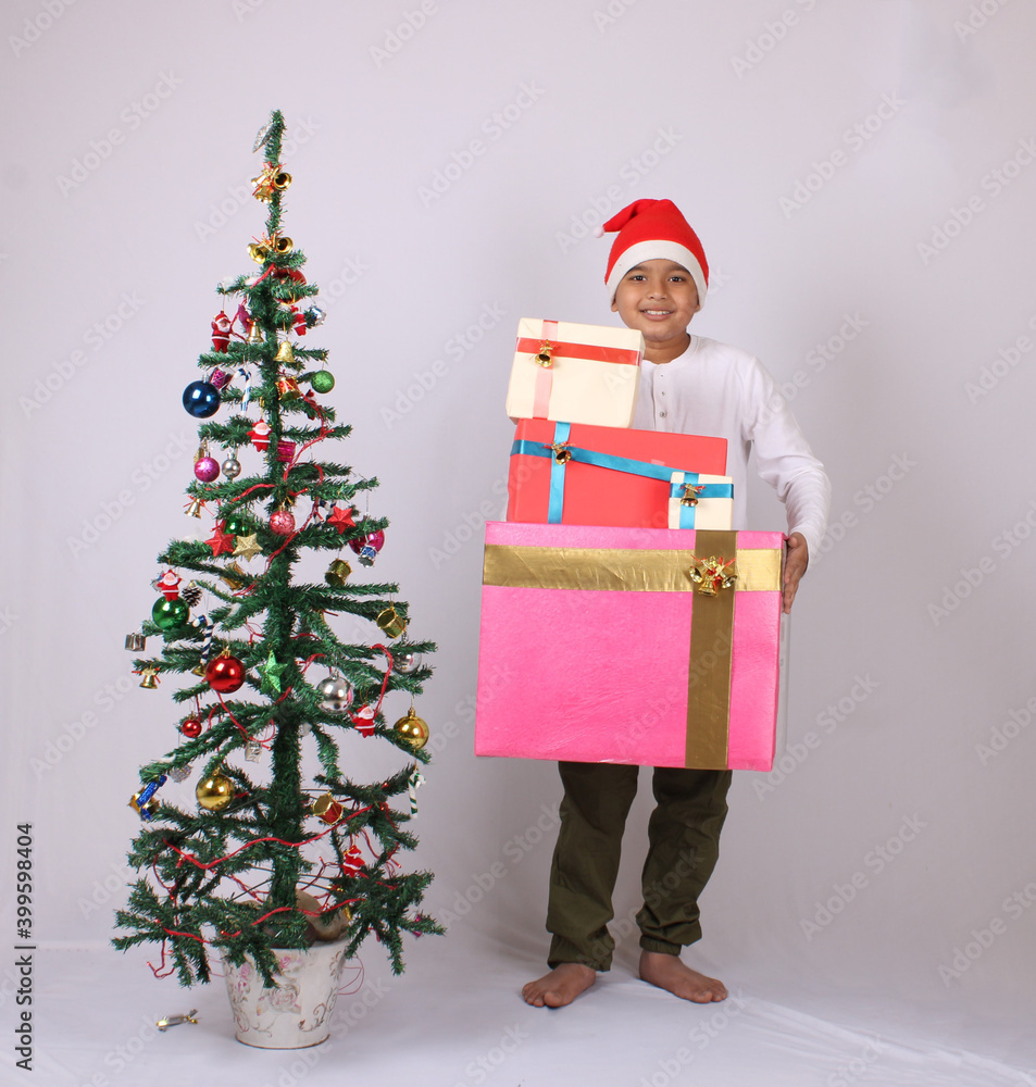 Cute Indian boy or kid holding christmas gifts.