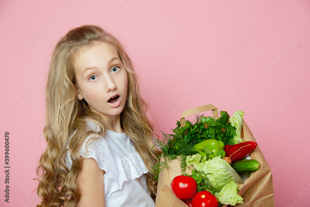 Cute girl on a pink background with vegetables Cute girl on a pink background with vegetables