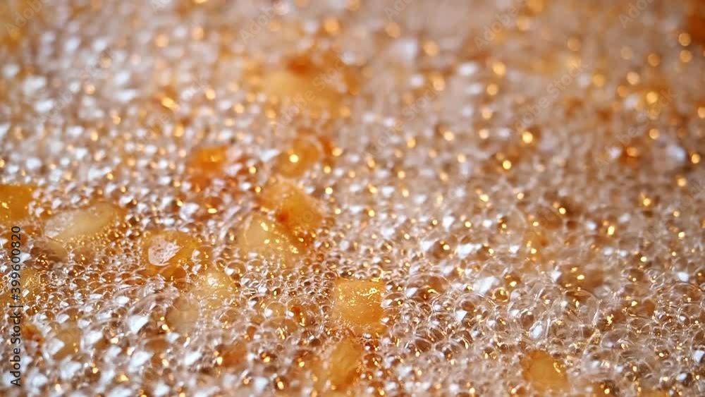 Making of crispy pork cracklings in SLOW MOTION HD VIDEO. Fried pieces of pork skin floating in lard and foam on pan. Making of crispy pork cracklings in SLOW MOTION HD VIDEO. Fried pieces of pork skin floating in lard and foam on pan.