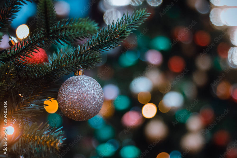 Brown silver glass ball on Christmas tree big on blurry colorful background. Selective focus Brown silver glass ball on Christmas tree big on blurry colorful background. Selective focus
