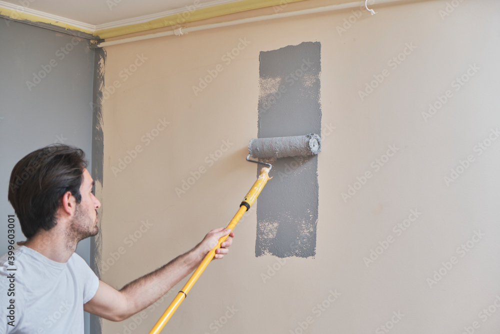 Young handsome man painting his walls Young handsome man painting his walls