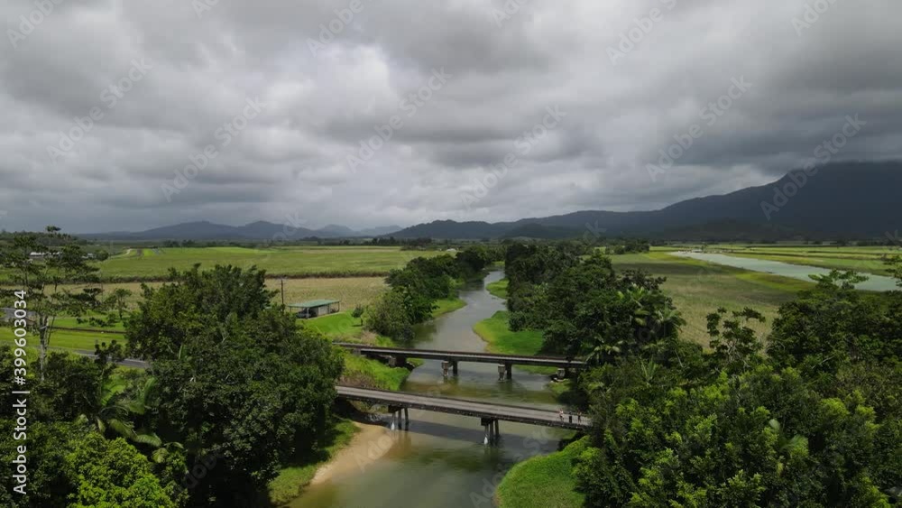 Aerial view looking down at a small country road bridge spanning over a crocodile in infested river Aerial view looking down at a small country road bridge spanning over a crocodile in infested river