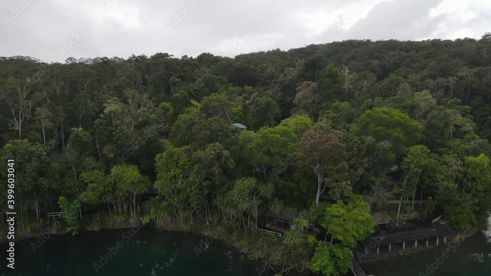 Aerial video showing a popular holiday area on a volcanic crater lake with a pontoon floating by the shore Aerial video showing a popular holiday area on a volcanic crater lake with a pontoon floating by the shore