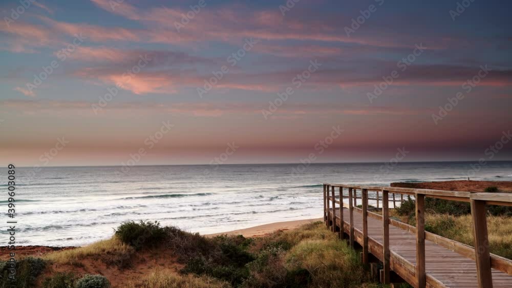 Coast landscape at morning. Time lapse of clouds moving over seashore with wooden path to sea water. Cala Magre beach in Calblanque Regional Park, Murcia region Spain. Coast landscape at morning. Time lapse of clouds moving over seashore with wooden path to sea water. Cala Magre beach in Calblanque Regional Park, Murcia region Spain.