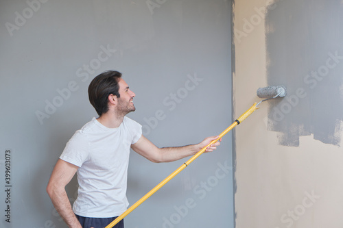 Young handsome man painting his walls photo